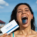 Woman with a blue tongue with her eyes closed holding a blue cannatine troscriptions box